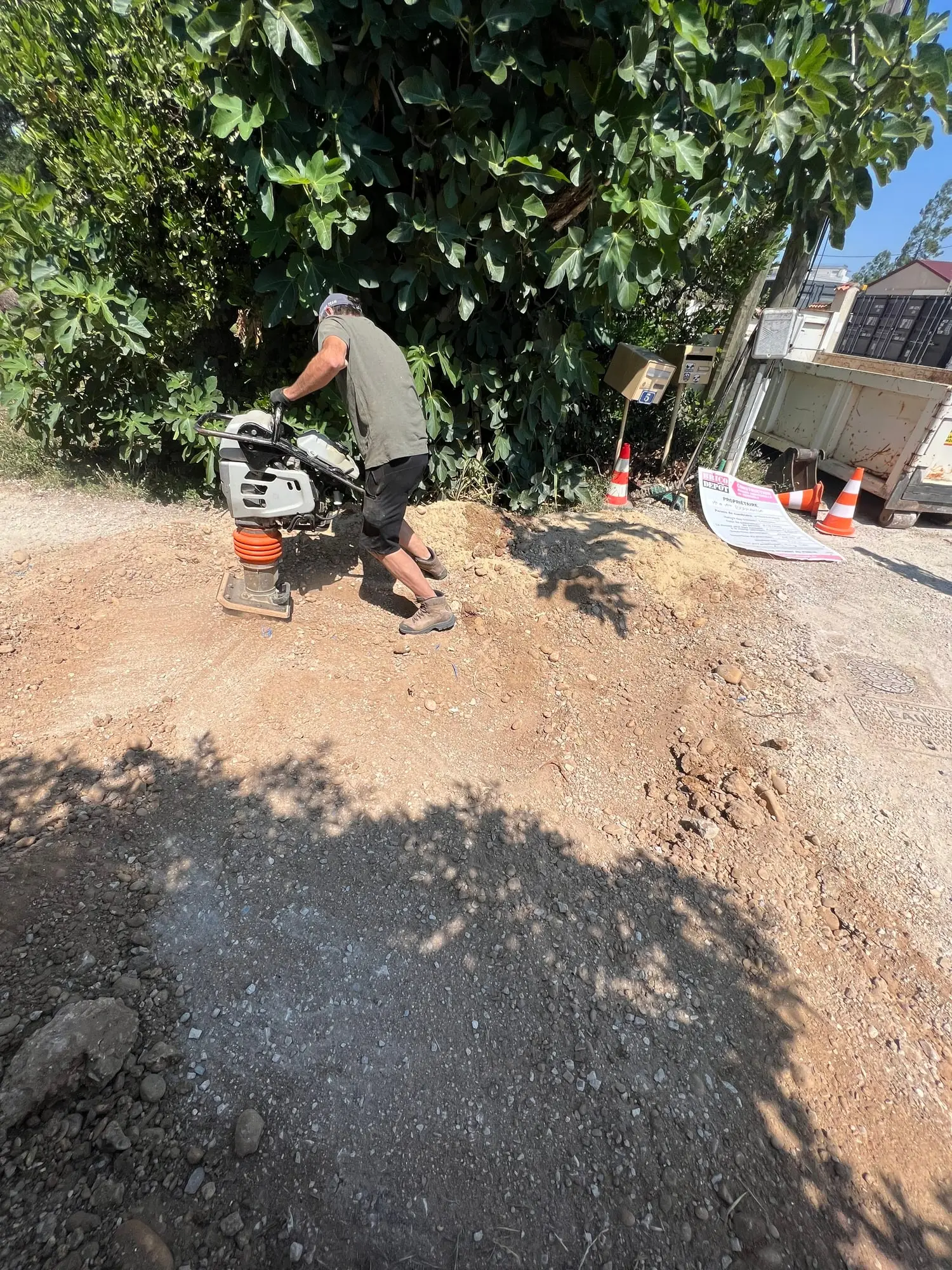Compactage du remblai à la pilonneuse après fermeture de la tranchée