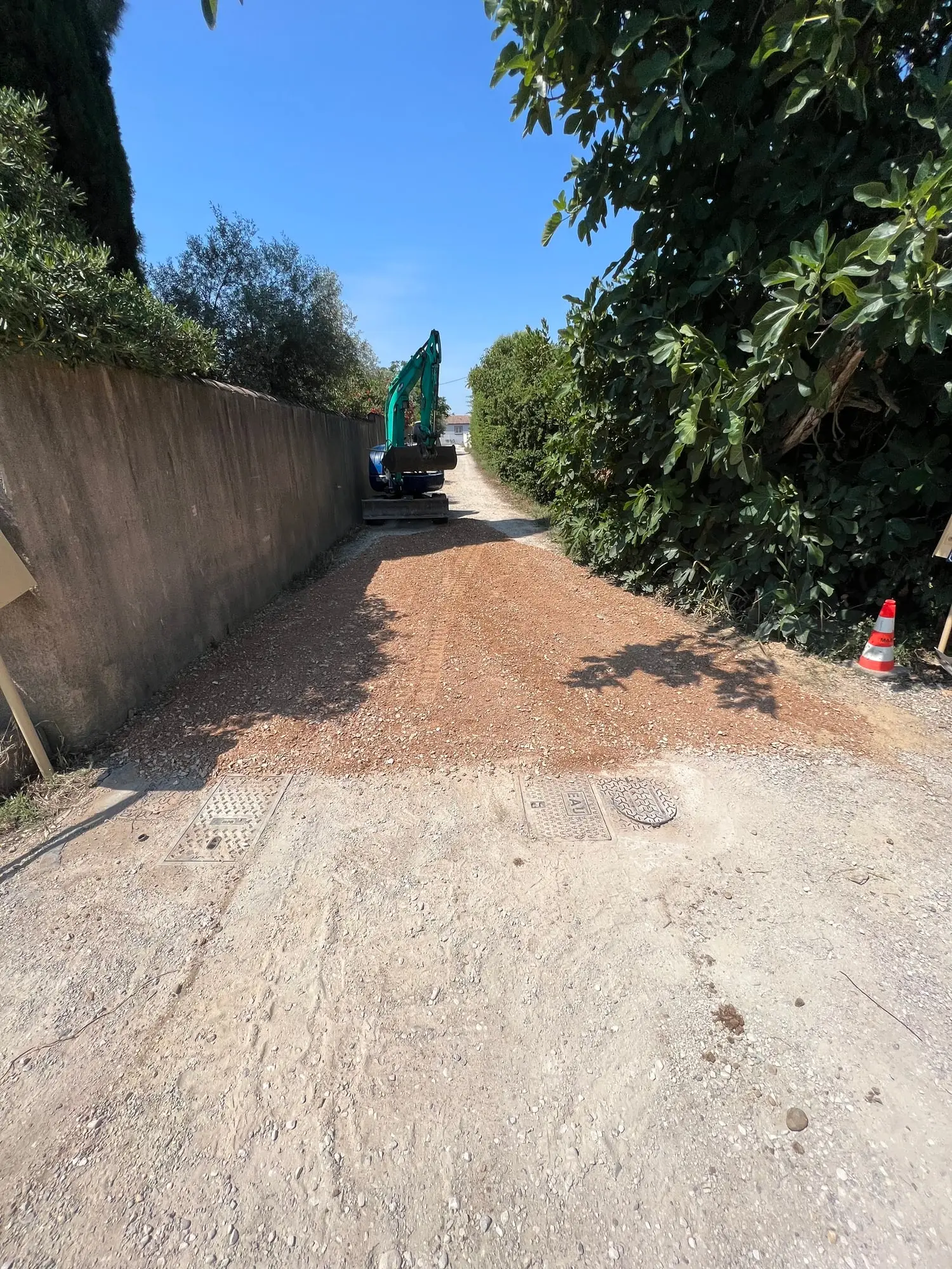 Chemin d’accès rechargé et compacté entre les deux murs