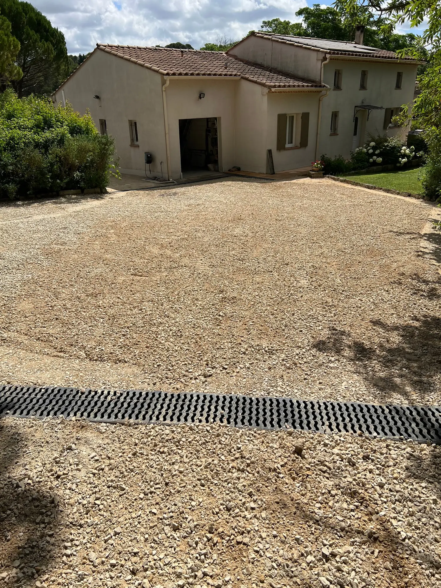 Cour terminée en gravier avec caniveau traversant