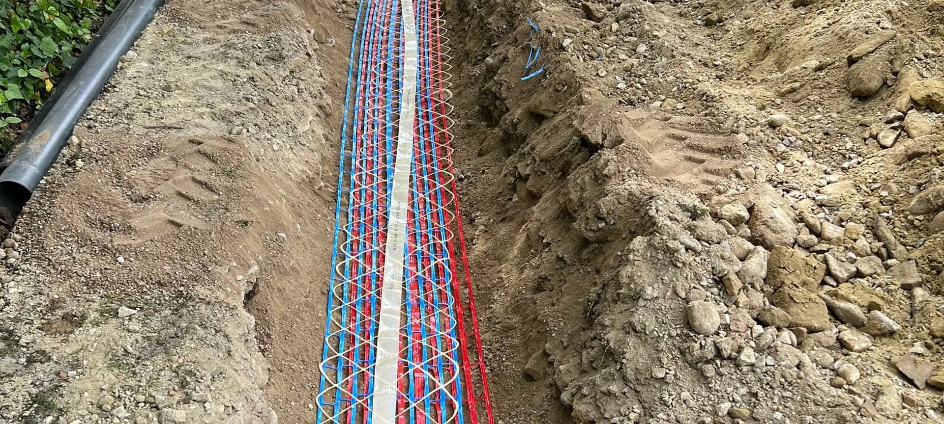 Tranchée de réseaux ouverte sur toute la longueur d’une allée, grillages avertisseurs en place